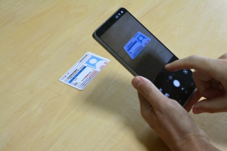 身分証明書をスマートフォンで撮影している様子