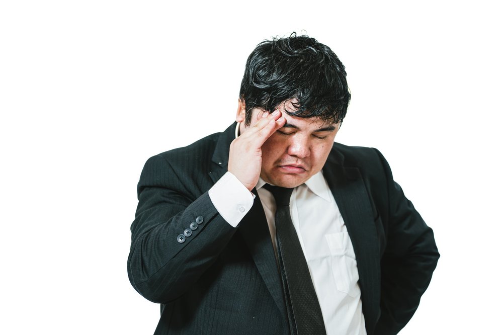 頭を抱えて悩む男性